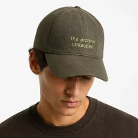 کلاه کپ کتان منگو زیتونی (مدل mo1007) روی سر مدل